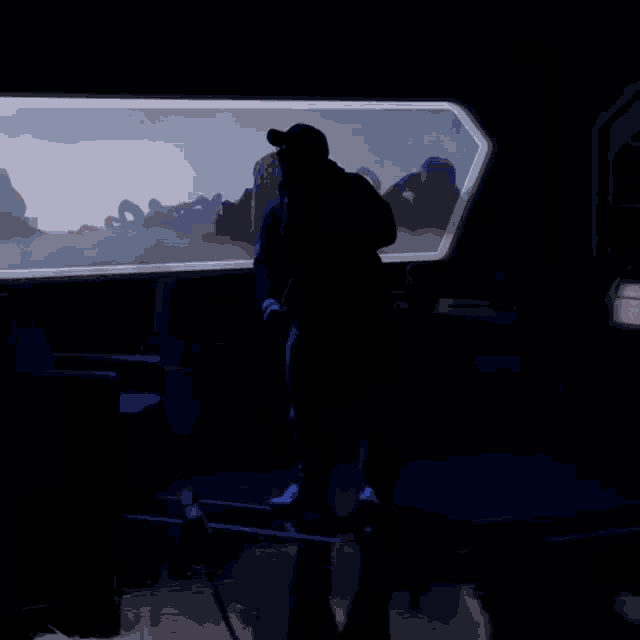 a silhouette of a man standing in a dark room