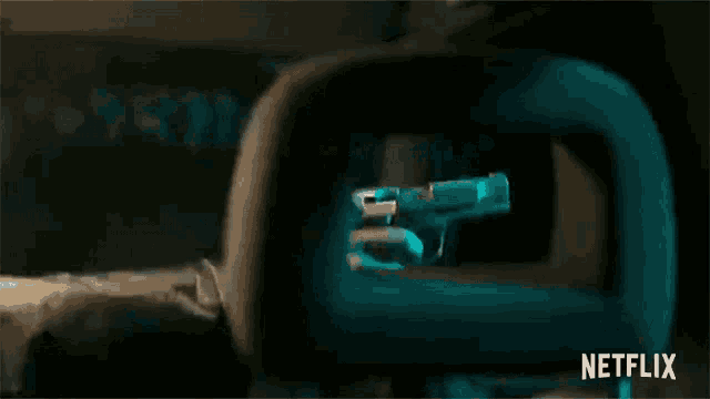 a netflix ad shows a man holding a gun in a dark room