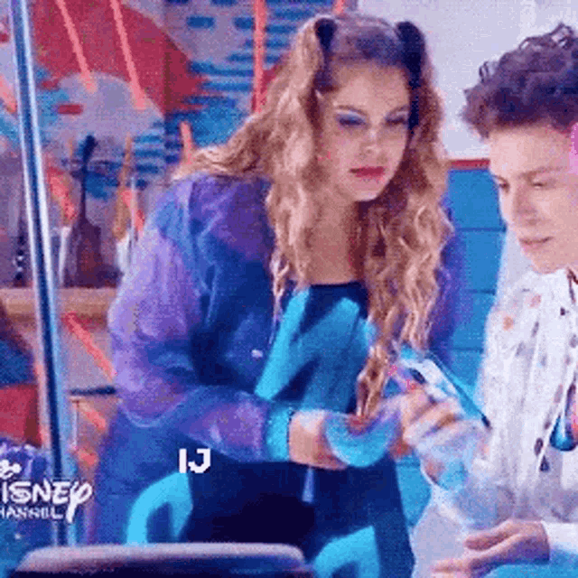 a man and a woman are sitting next to each other in a room . the woman is wearing a purple jacket .