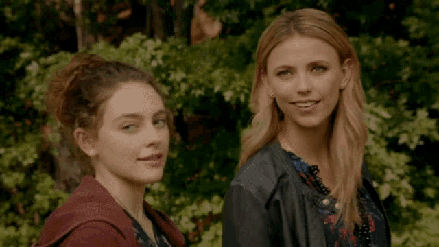 two young women are standing next to each other and smiling