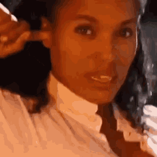 a close up of a woman plugging her ears with her finger .