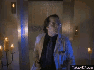 a man in a lab coat is standing in a room with many candles