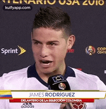 a soccer player is talking into a microphone while wearing a white shirt .