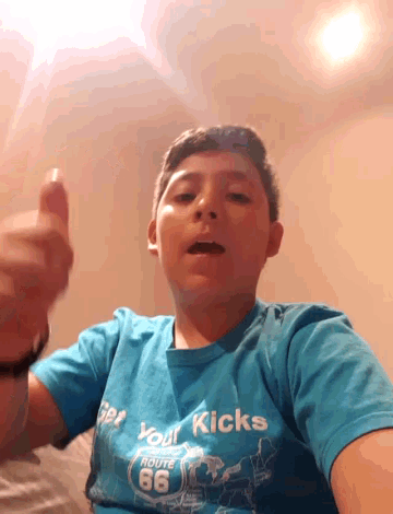 a boy wearing a blue shirt that says " get your kicks "
