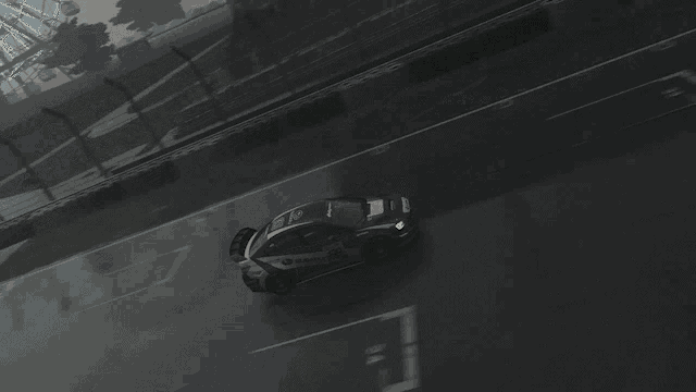 a car with the number 24 on the side is driving down a wet track