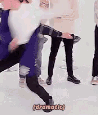 a group of people are standing in a room and one of them is dancing and the word dramatic is on the bottom of the screen .