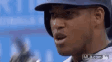 a close up of a baseball player wearing a helmet and holding a bat