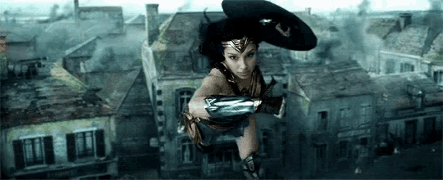 wonder woman is flying through the air over a city while wearing a hat and gloves .