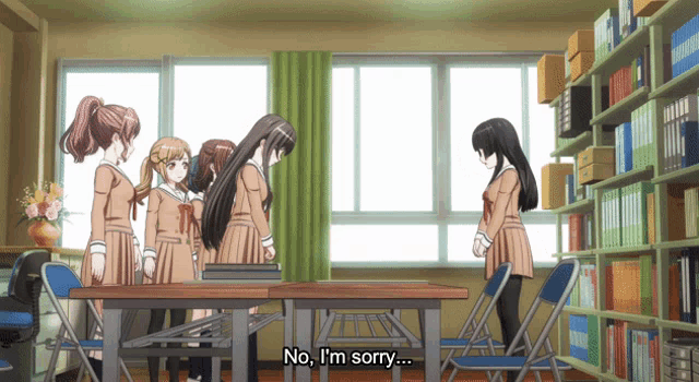 a group of girls are standing around a table and one of them is saying no i 'm sorry
