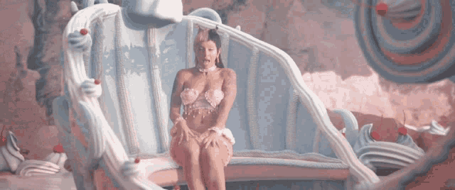 a woman in a bikini is sitting on a couch with ice cream on it