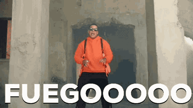 a man in an orange hoodie is standing in front of a sign that says fuegooooo