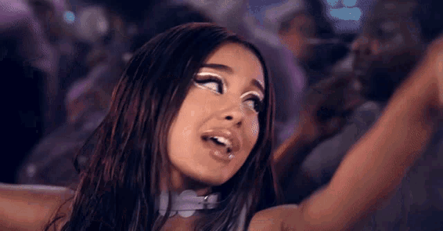 a close up of a woman 's face with a white choker around her neck