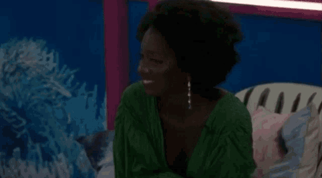 a woman in a green dress is sitting on a bed with a zebra print headboard .