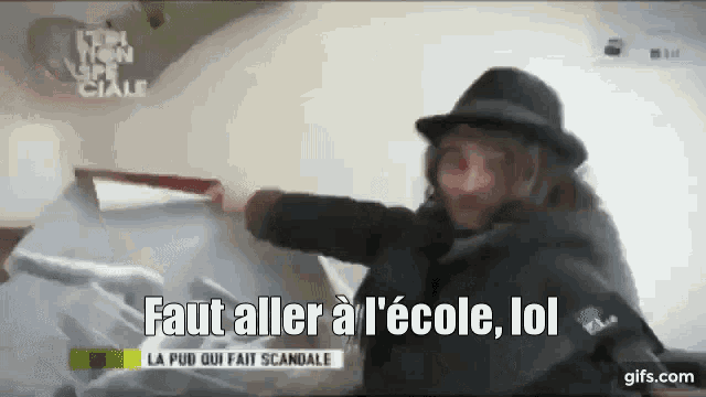 a man in a hat is holding a knife and says faut aller a l' école lol