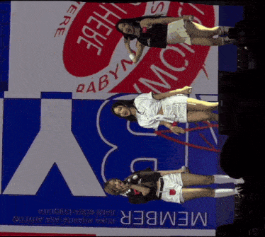 three women are standing in front of a large sign that says member