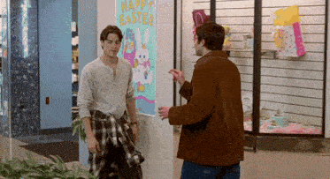 two men are standing in front of a happy easter poster