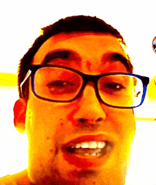 a close up of a man wearing glasses and making a funny face