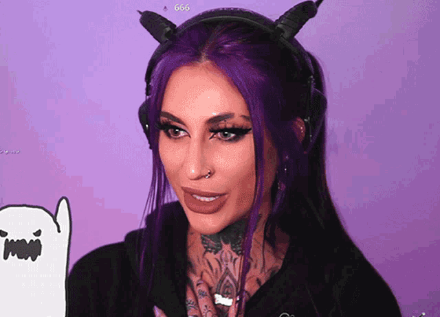 a woman with purple hair is wearing headphones with horns and the number 666 on the bottom