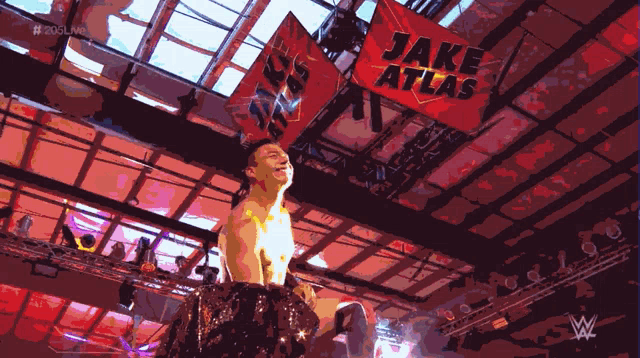 a man in a wrestling ring with a banner that says jake atlas
