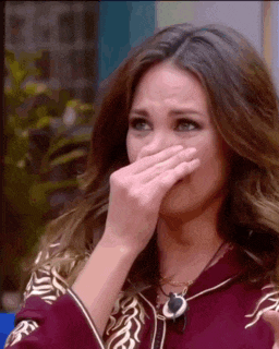 a woman is covering her face with her hand while crying .