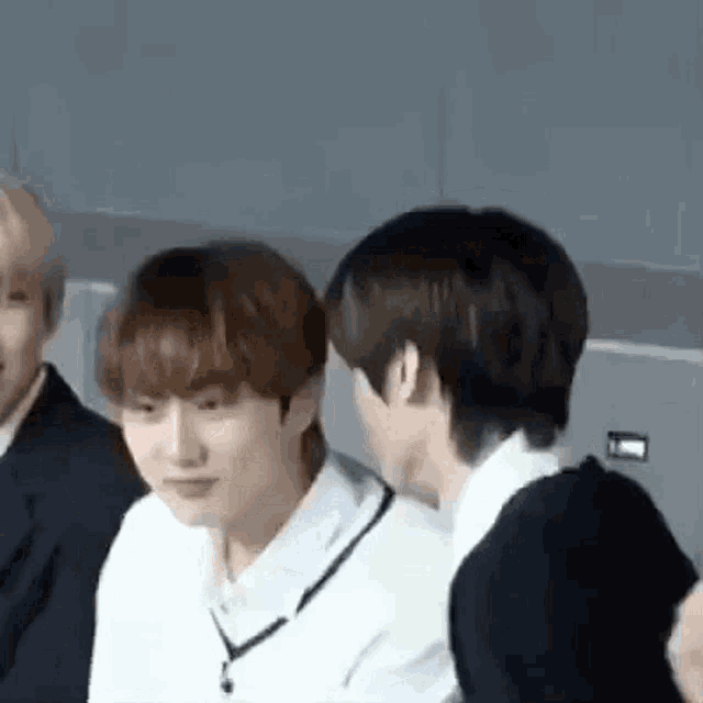 a group of young men are standing next to each other and one of them is looking at the camera .