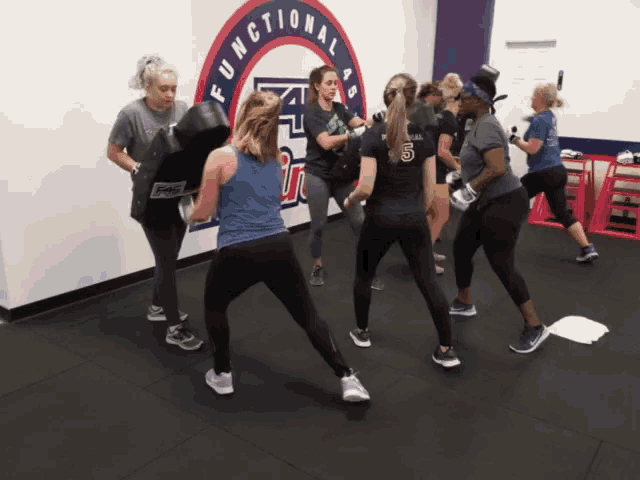 a group of women are boxing in a functional abs gym