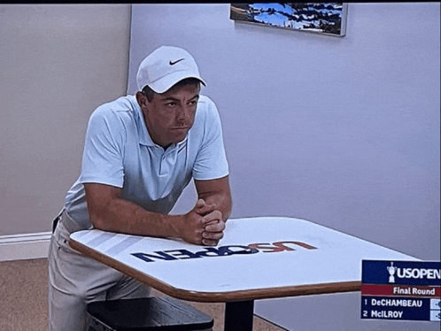 a man sitting at a table with the us open logo on it