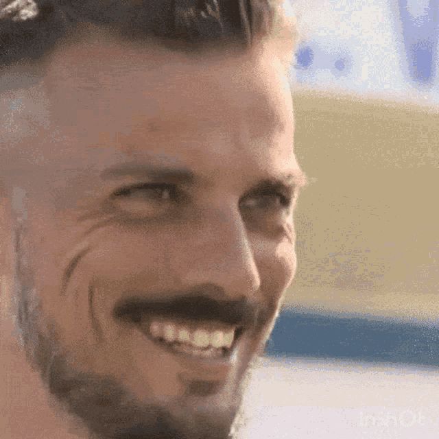 a man with a beard and mustache is smiling