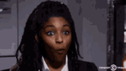 a woman with dreadlocks has a surprised look on her face .