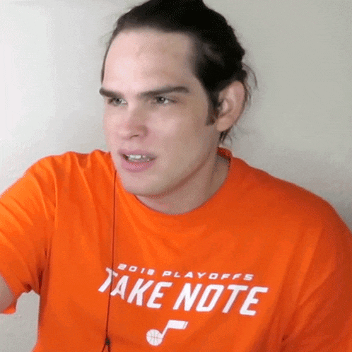 a man wearing an orange shirt that says " take note "