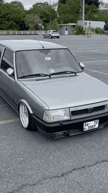 a silver car with a license plate that says 34 td 3550 is parked in a parking lot