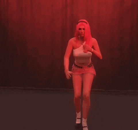 a woman with pink hair is standing in front of a red wall