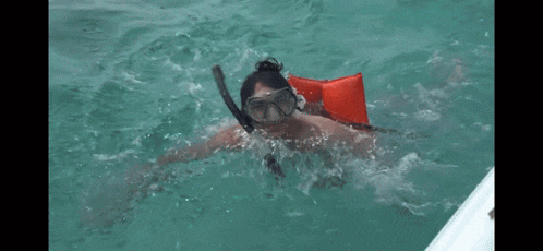 a person wearing a life jacket and goggles is swimming in the water