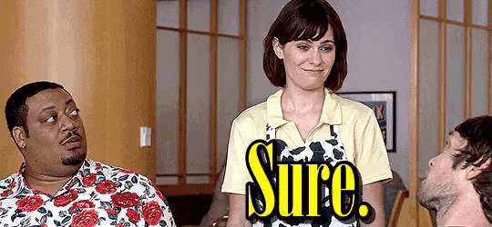 a man and a woman are standing next to each other and the woman is wearing an apron that says sure .