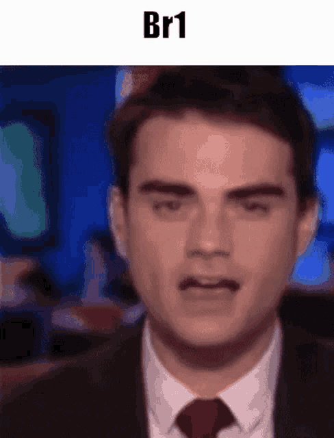 a man in a suit and tie is making a funny face with the text br1 above him
