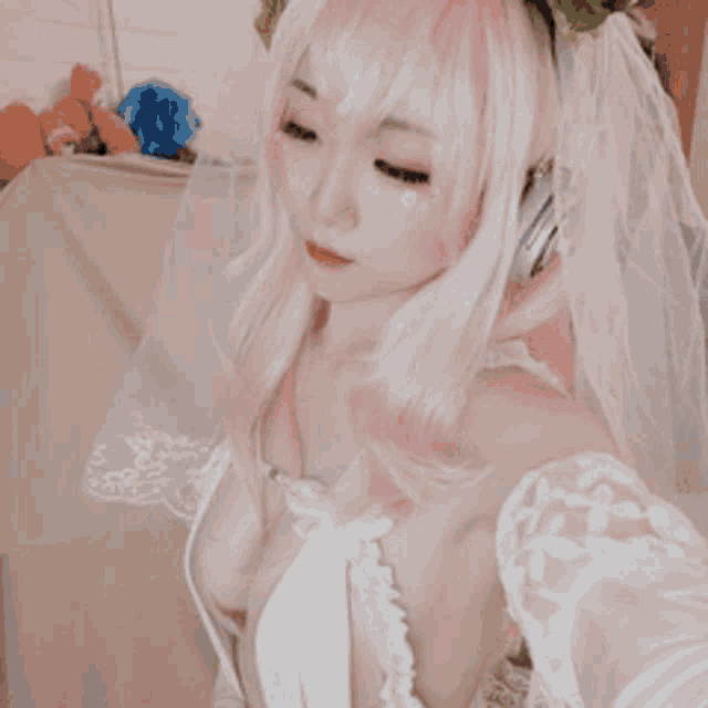 a woman with pink hair is wearing a veil and headphones