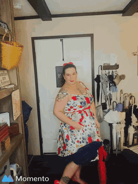 a woman in a floral dress is standing in front of a door with a sign on it that says families are forever