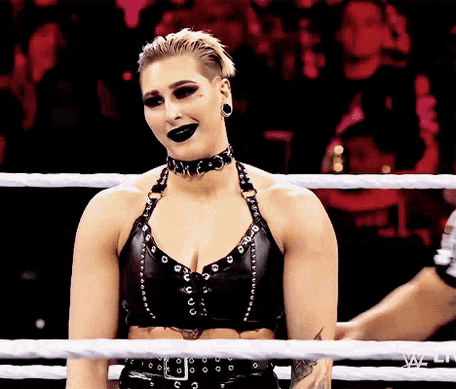 a woman in a wrestling ring with the word wwe on the bottom left