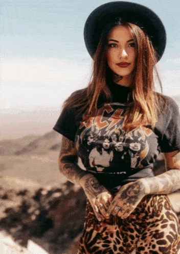 a woman wearing a hat and a t-shirt that says ac dc on it