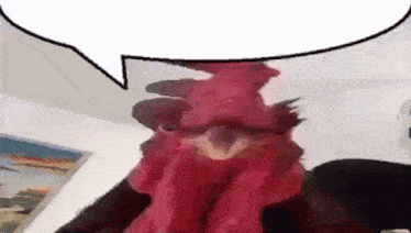 a red rooster with a speech bubble above it .