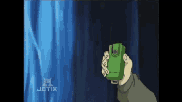 a person is holding a green device in front of a blue curtain with the word jetix on the bottom