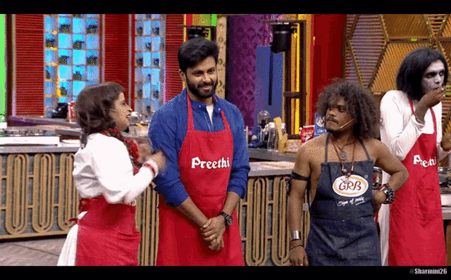a group of people wearing red aprons with preethi on them