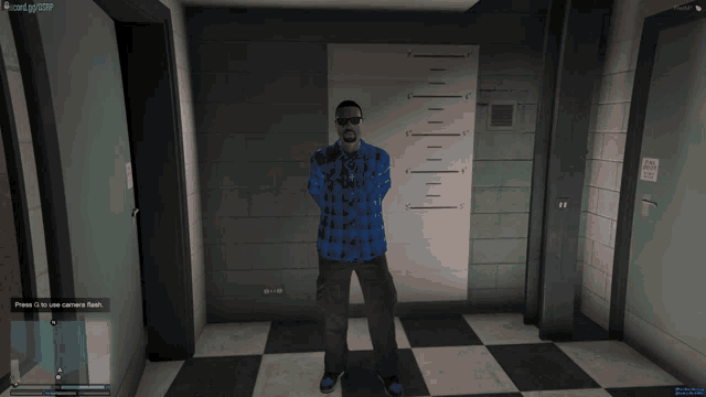 a man in a blue plaid shirt and black pants is standing in front of a wall with a picture of him on it