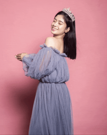 a woman wearing a tiara and a blue dress is smiling