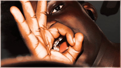 a person with braces on their teeth is covering their face with their hand