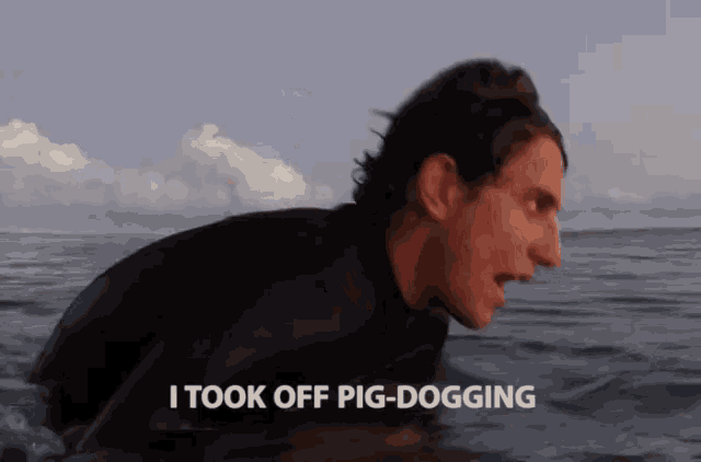 a man in a wetsuit is swimming in the ocean and says i took off pig-dogging