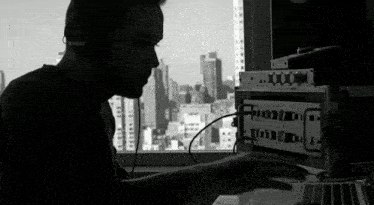 a man wearing headphones sits in front of a computer