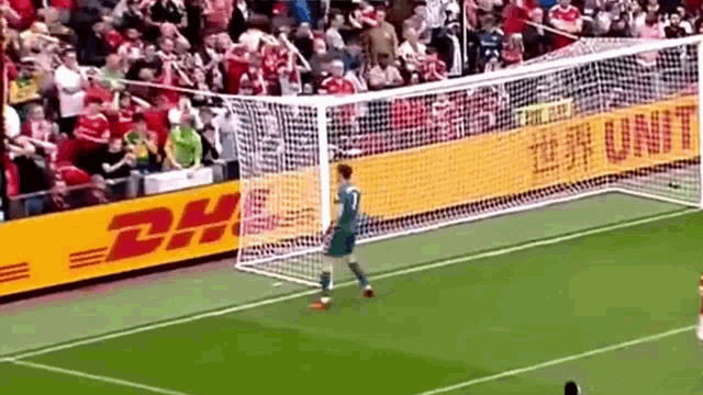 a soccer goalie is standing in front of a dhl banner