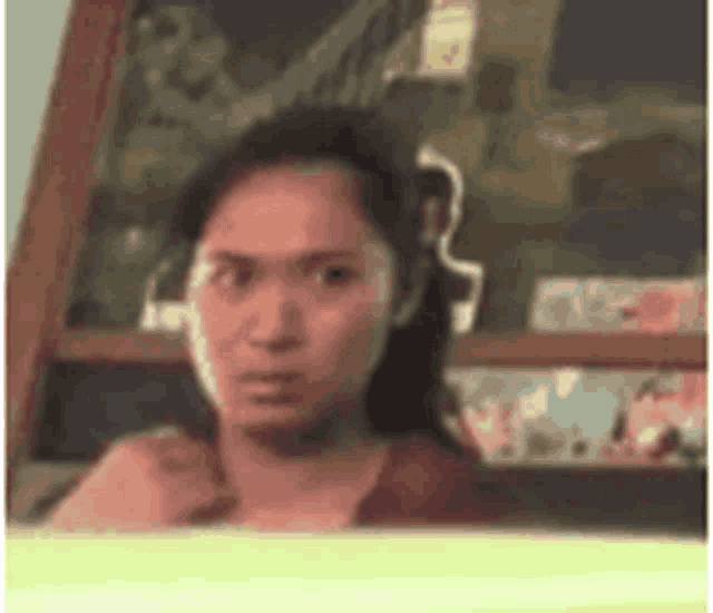 a woman is looking out of a window and making a face .