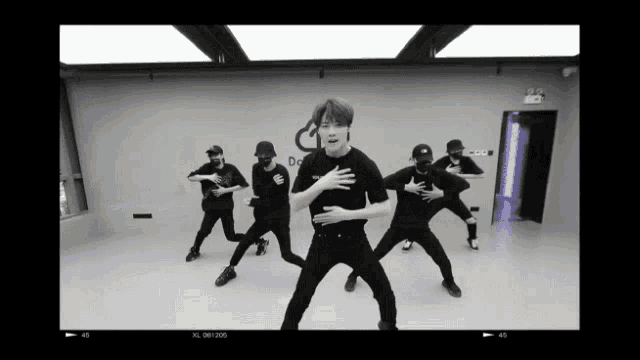 a group of men are dancing in a room with a sign that says do on it